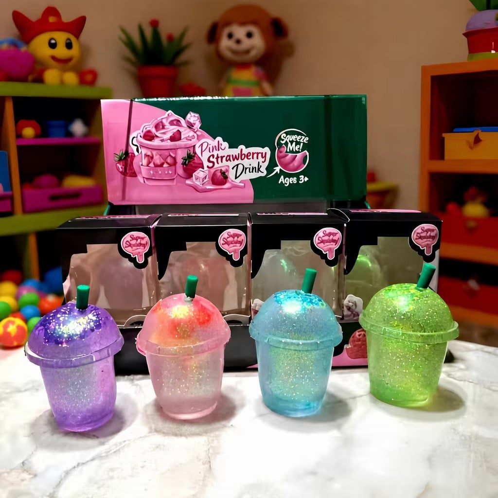 Four glitter milk tea cup squishies in purple, pink, blue and green with domed lids and straws