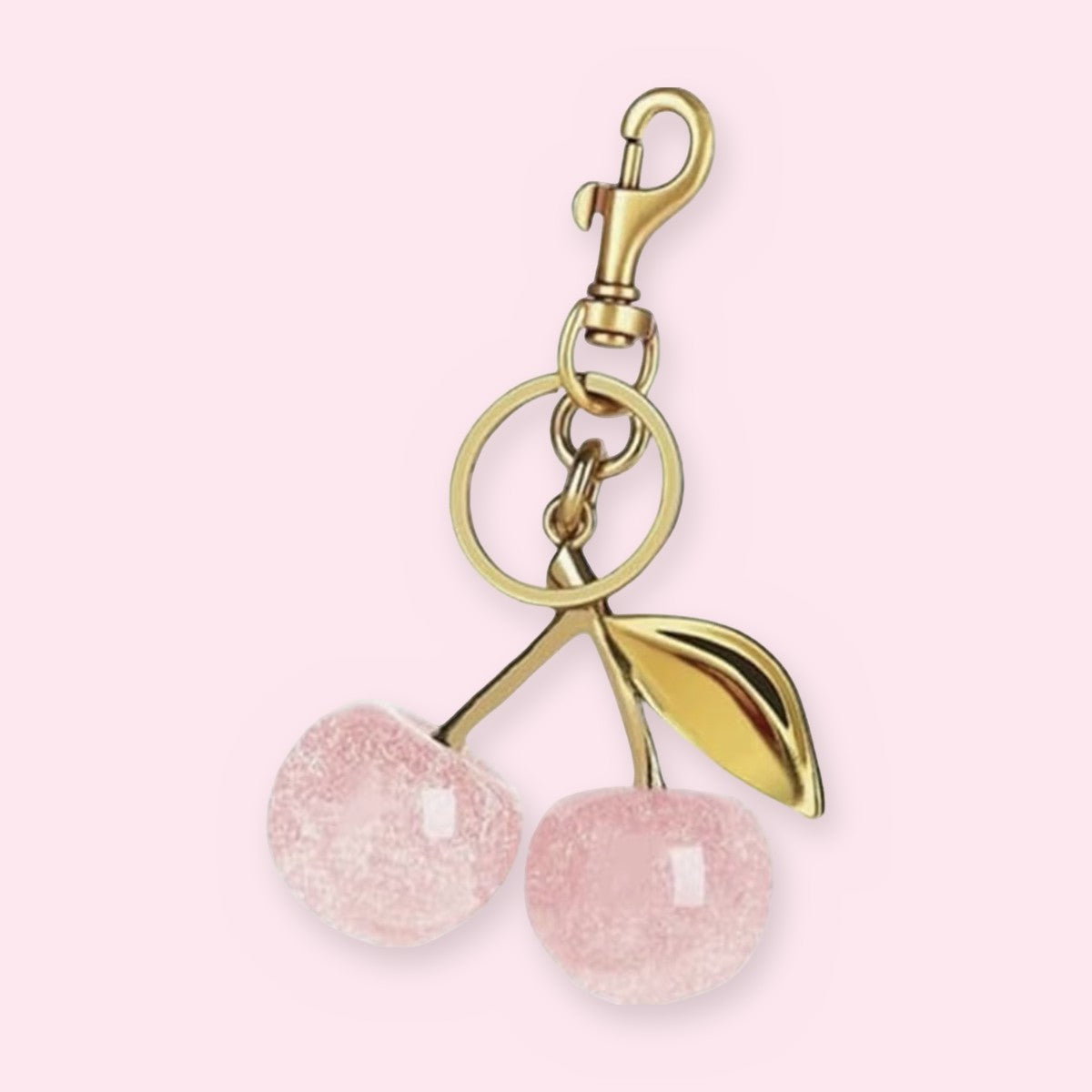 Pink glitter resin double-cherry keychain with a gold-tone leaf, clasp and key ring