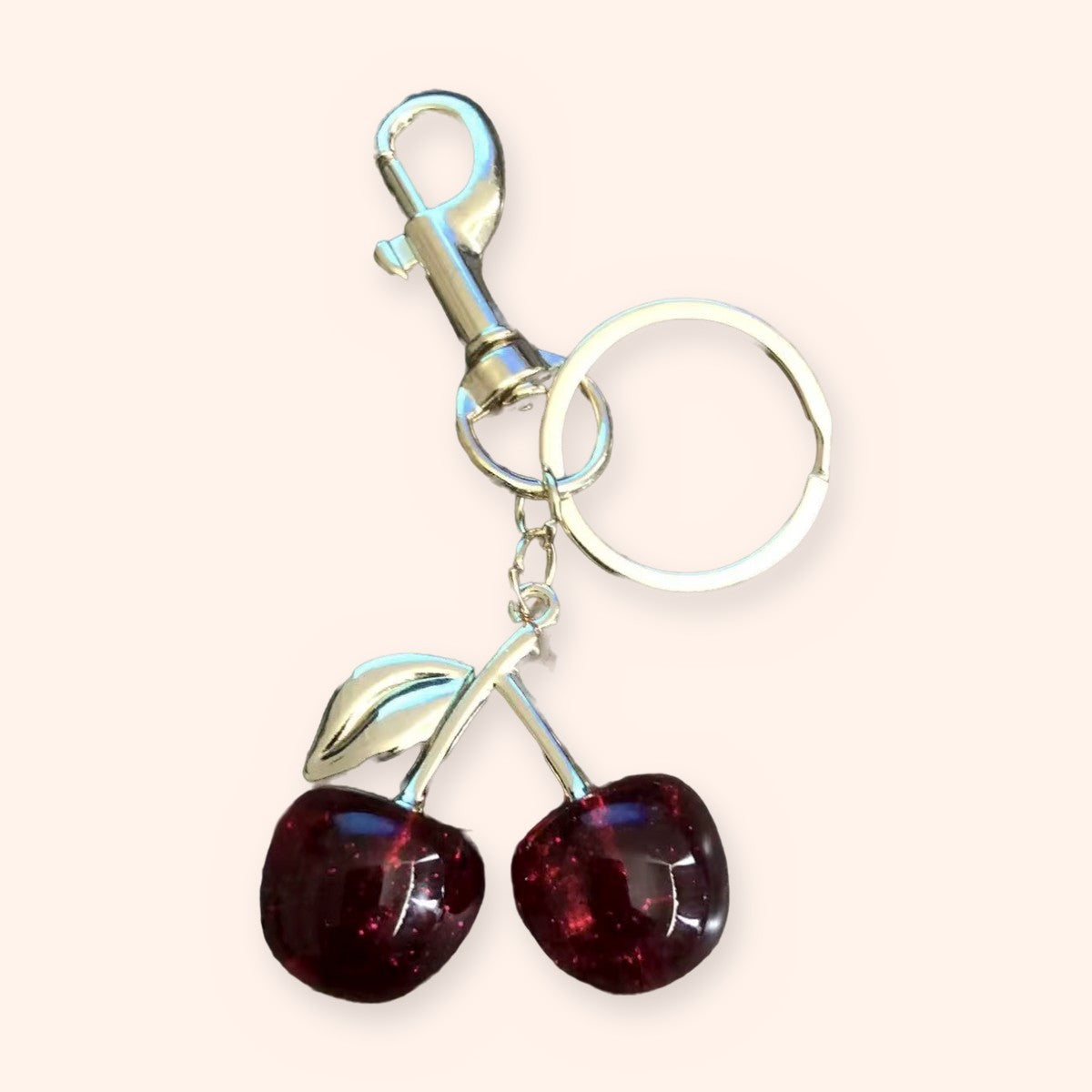 Red glitter resin double-cherry keychain with a silver-tone leaf, clasp and key ring